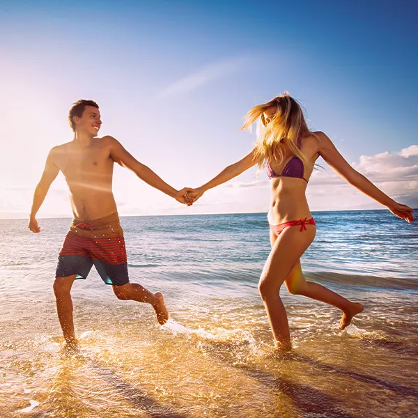Couple courant main dans la mer.
