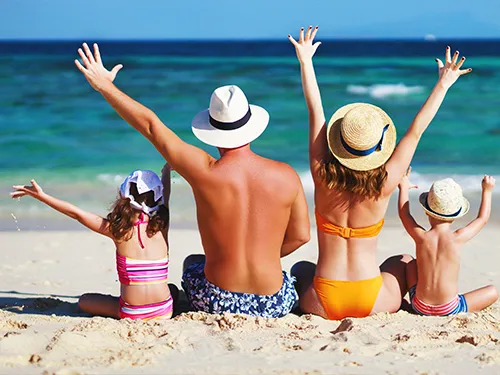 Familie am Strand mit Hüten